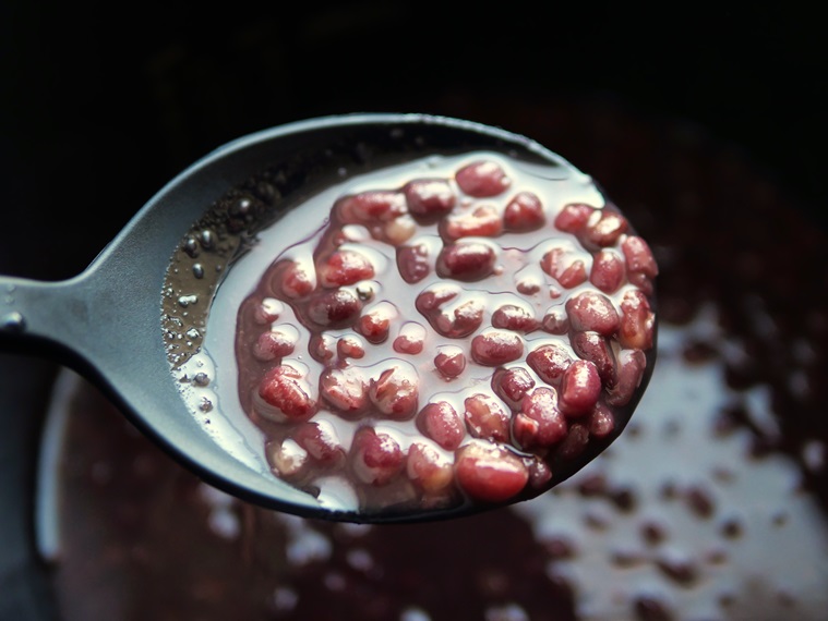 電気圧力鍋でやわらかく煮た煮小豆を、内釜からシリコンスプーンですくっている様子