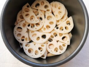 電気圧力鍋の内釜に、たけのことれんこんを順に並べ入れた状態