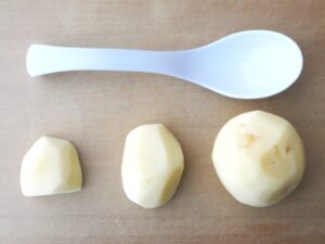 一口大、一口大よりやや大きめ、一口大の2倍に切ったじゃがいもと、れんげスプーンを置いた大きさ比較