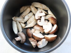 電気圧力鍋の内釜にごぼう、しいたけを並べ入れたところ