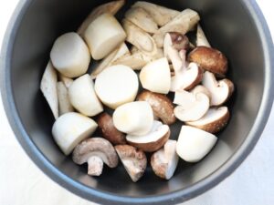 電気圧力鍋の内釜に、ごぼう、しいたけ。さといもを並べ入れたところ