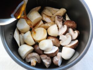 電気圧力鍋の内釜に煮汁を注いでいる様子