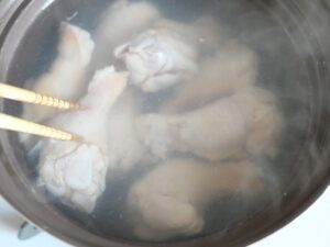 鍋で鶏手羽元を湯通ししている様子