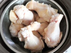 湯通しした鶏手羽元をざるに上げた状態