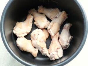 電気圧力鍋の内釜に鶏手羽元を並べた状態