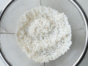 もち米を洗ってざるに上げた様子(参鶏湯の下ごしらえ)