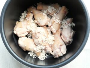 鶏手羽元の上にもち米を入れた様子