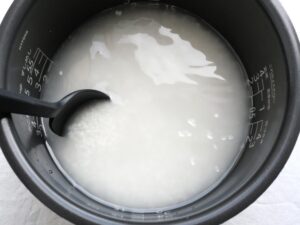 内釜の米と水をかき混ぜて、塩を溶かしている様子