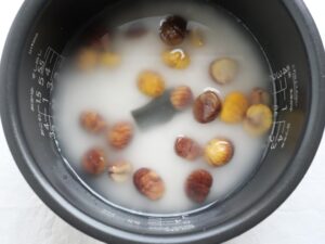 内釜の米の上に甘栗を散らしてのせた様子。炊飯前の状態