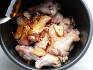 内釜に甘辛煮用の煮汁(醤油・みりんなど)を注いでいる様子