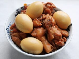 器に盛り付けた鶏手羽元と卵の甘辛煮。手羽元に甘辛味がしみ込み、ゆで卵も茶色く色付いた仕上がり