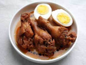 白い皿に盛った鶏手羽元3本と、半分に切ったゆで卵2片