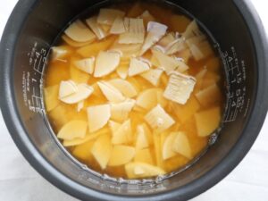 米の上に、たけのこの水煮を並べ入れた様子