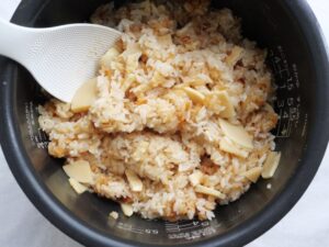 炊き込みご飯をしゃもじでかき混ぜている様子