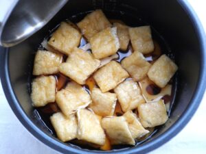 れんこんは煮汁に浸かり、油揚げは煮汁に浮いている様子