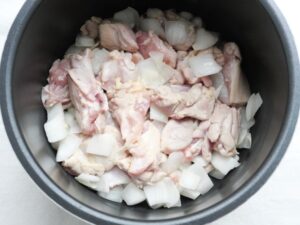 電気圧力鍋の内釜に炒めた鶏もも肉などの具材を入れた状態