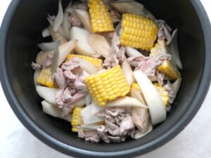 内釜に炒めた具材（とうもろこし、豚肉、玉ねぎ、ごぼう）を入れたところ