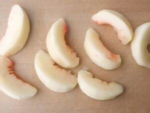 桃のコンポート用に皮をむいて8等分にした桃