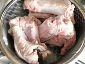 ざるに上げた、豚スペアリブ。湯通しが終わったところ