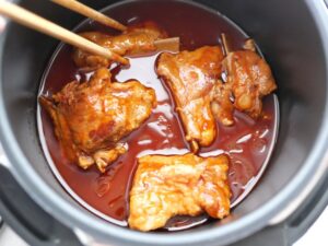 豚スペアリブを菜箸で裏返したところ。煮込み直前の様子