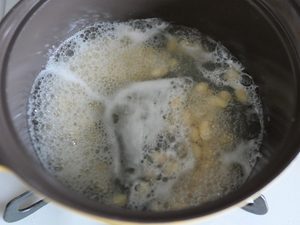 大豆と浸し水を入れた鍋が沸騰し、白い泡が出ている状態
