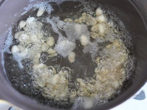 沸騰した湯の中で大豆が躍っている様子