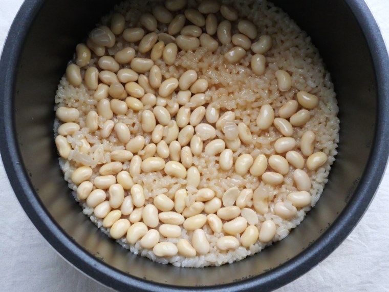 炊き上がった大豆ご飯。大豆が炊けたご飯の上で大豆がふっくら仕上がっている。