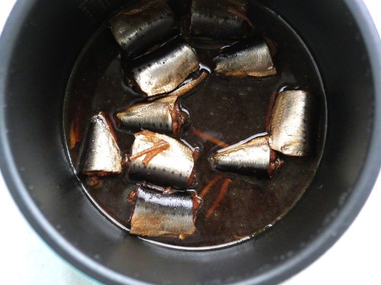 電気圧力鍋で煮込んだ、いわしのさっぱり煮。黒っぽい煮汁の中にふっくらとしたいわし